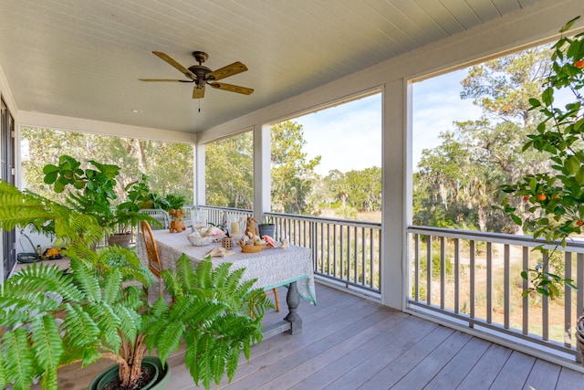 unfurnished sunroom featuring ceiling fan