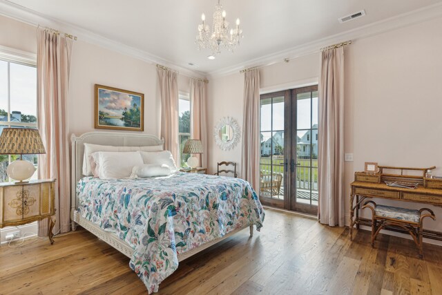 bedroom with access to outside, an inviting chandelier, french doors, hardwood / wood-style flooring, and ornamental molding