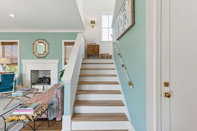 stairs featuring hardwood / wood-style flooring and ornamental molding