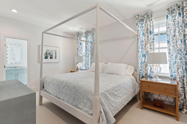 bedroom featuring light carpet, connected bathroom, and sink