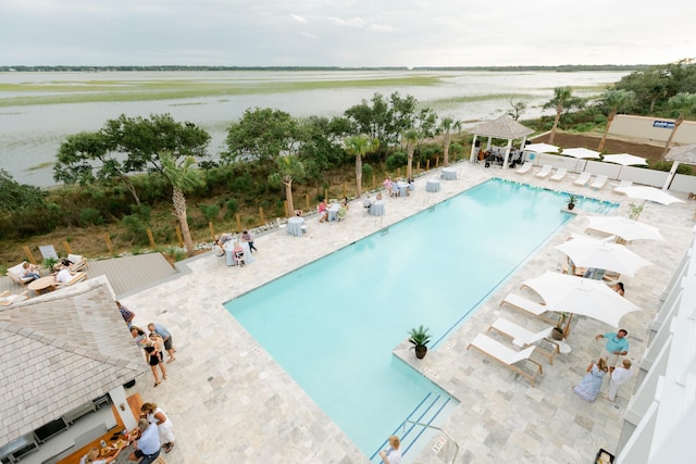 view of swimming pool with a water view and a patio