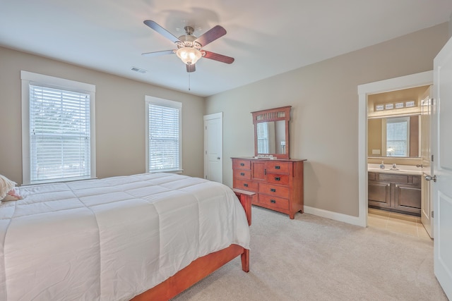 carpeted bedroom featuring ceiling fan and ensuite bath