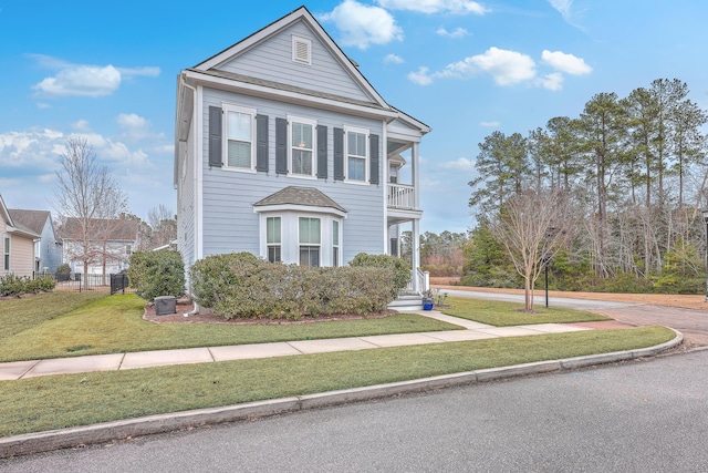 view of front of property featuring a front yard and a balcony