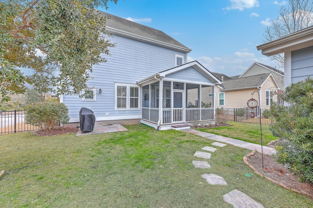 back of property featuring a yard, a sunroom, and a patio