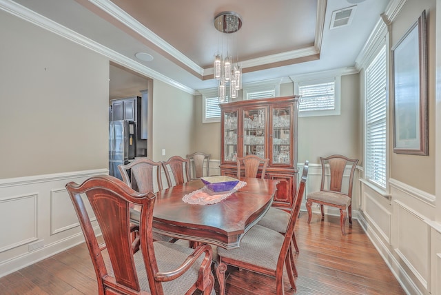 dining room with a chandelier, a tray ceiling, crown molding, and dark hardwood / wood-style floors