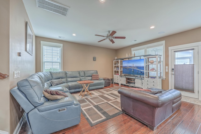 living room featuring wood-type flooring, ceiling fan, and a wealth of natural light