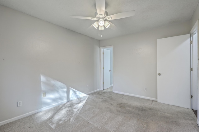 carpeted empty room featuring ceiling fan and a textured ceiling