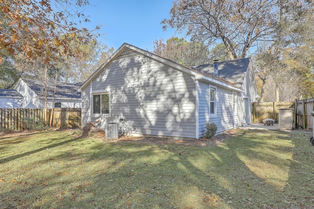 back of house featuring a lawn, a patio area, and central AC unit