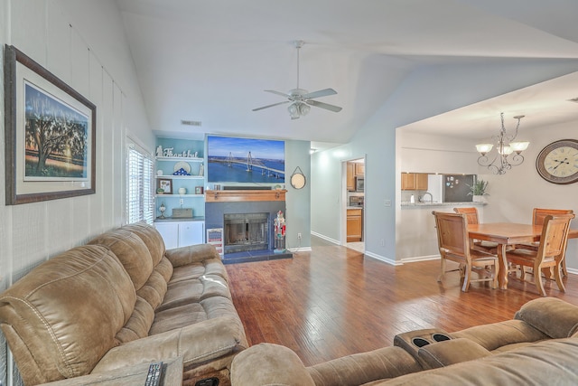 living room with light hardwood / wood-style flooring, ceiling fan with notable chandelier, vaulted ceiling, and sink