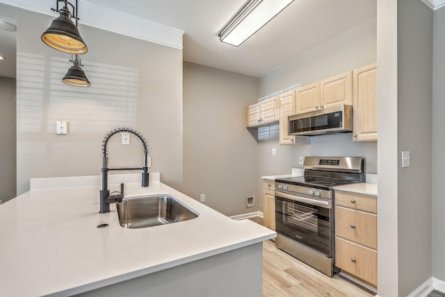 kitchen with sink, light hardwood / wood-style flooring, appliances with stainless steel finishes, decorative light fixtures, and light brown cabinets