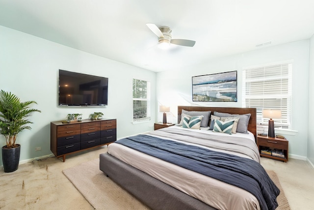 bedroom with multiple windows, light carpet, and ceiling fan