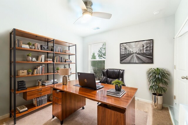 home office with light hardwood / wood-style floors and ceiling fan