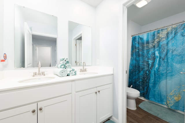 bathroom featuring hardwood / wood-style floors, vanity, toilet, and walk in shower