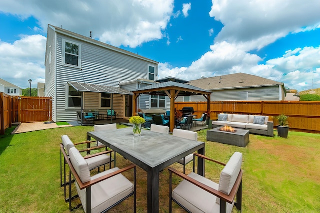 back of property featuring a gazebo, a yard, and an outdoor living space with a fire pit