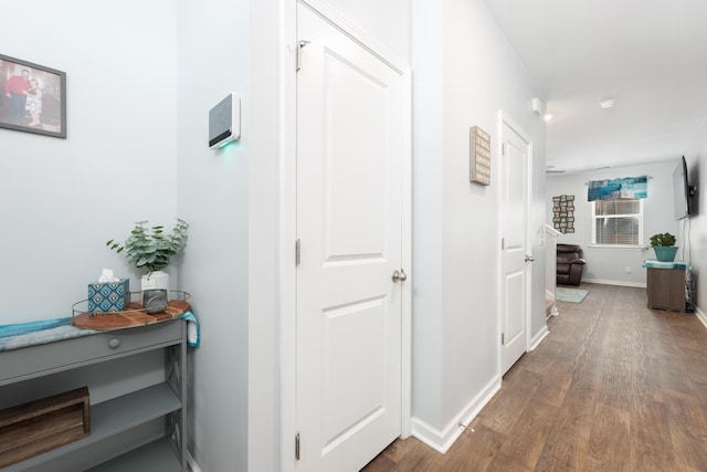 hallway with dark hardwood / wood-style flooring