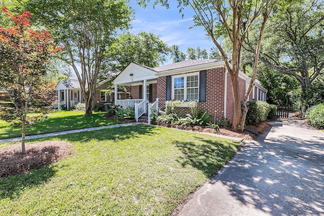 31 Lyttleton St, Charleston, SC 29407 - bungalow-style home with brick siding, covered porch, a front lawn, and driveway