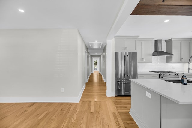 31 Lyttleton St, Charleston, SC 29407 - kitchen featuring stainless steel appliances, wall chimney range hood, light wood-style floors, light countertops, and baseboards
