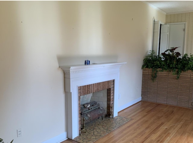 room details featuring ornamental molding, wood finished floors, a fireplace with flush hearth, and baseboards