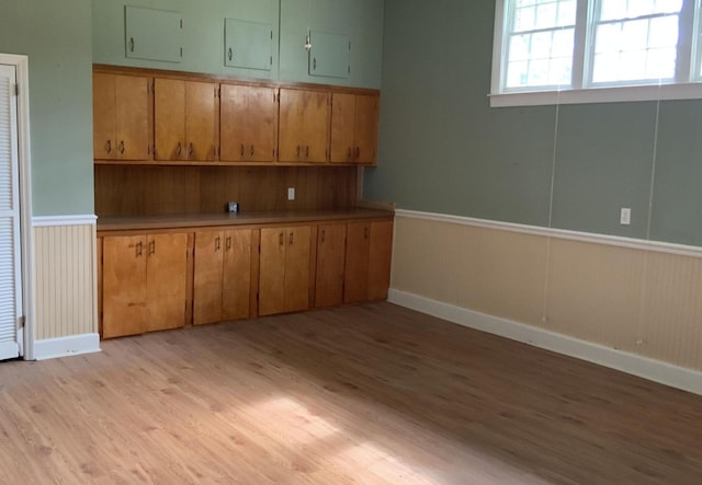 interior space with light countertops, light wood-type flooring, and brown cabinets