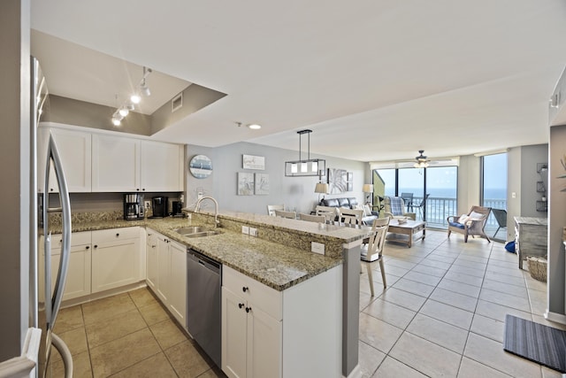 kitchen with stainless steel appliances, a sink, open floor plan, a peninsula, and light tile patterned flooring