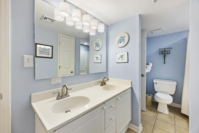 bathroom featuring toilet, tile patterned floors, double vanity, and baseboards