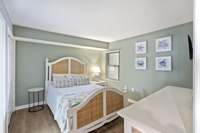 bedroom featuring wood finished floors and baseboards