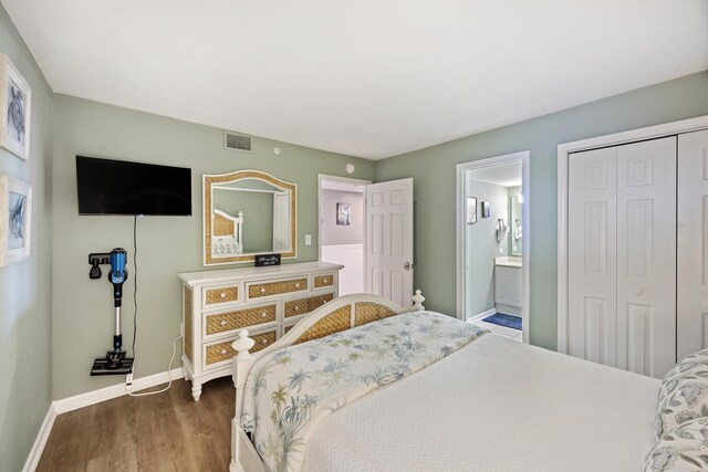 bedroom featuring wood finished floors, baseboards, a closet, and ensuite bathroom