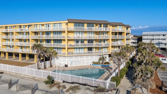 view of apartment building / complex with a community pool and fence