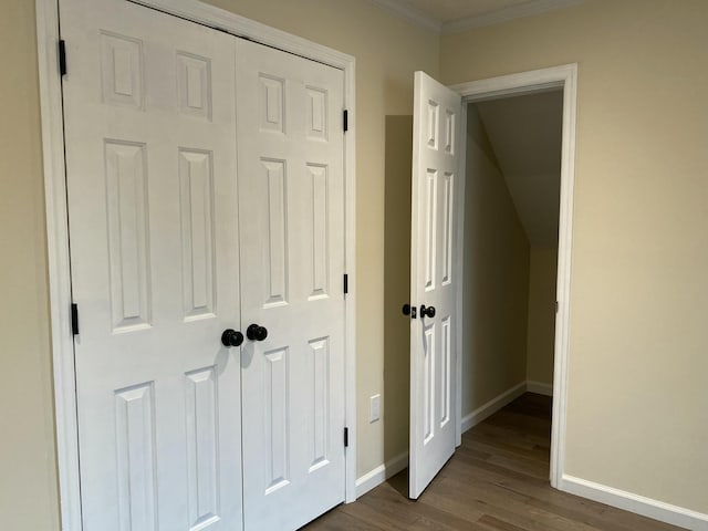 corridor featuring dark wood finished floors, crown molding, and baseboards