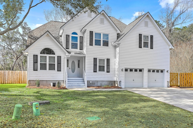 traditional-style house featuring a front yard, fence, driveway, roof with shingles, and an attached garage