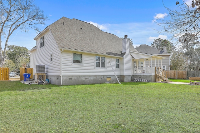 back of property with a yard, fence, a chimney, and crawl space