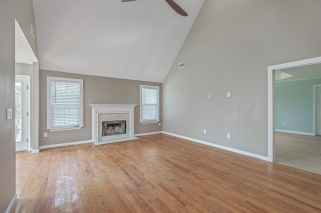 unfurnished living room featuring light wood-type flooring, visible vents, a healthy amount of sunlight, and a fireplace