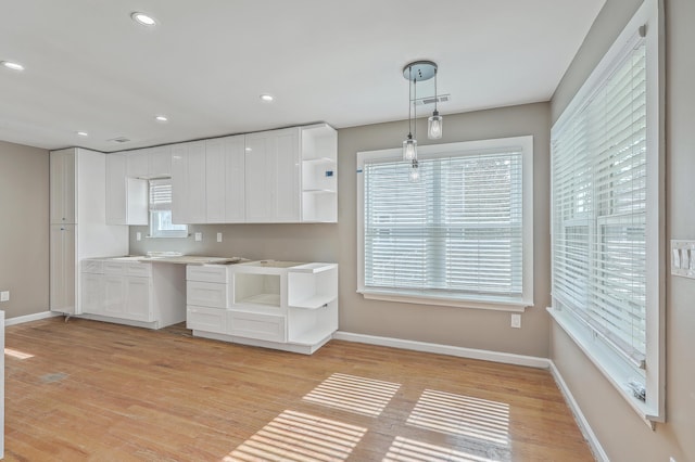 kitchen with light wood finished floors, white cabinetry, baseboards, and open shelves