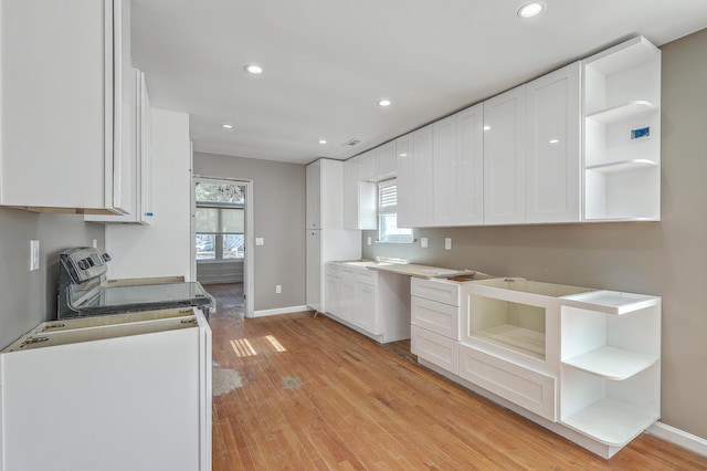 kitchen featuring white cabinetry, light wood-style floors, electric range oven, and open shelves