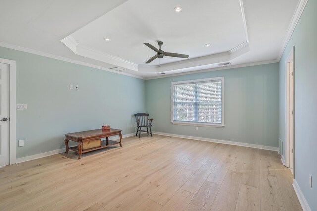 unfurnished room featuring a tray ceiling, light wood-style flooring, baseboards, and visible vents