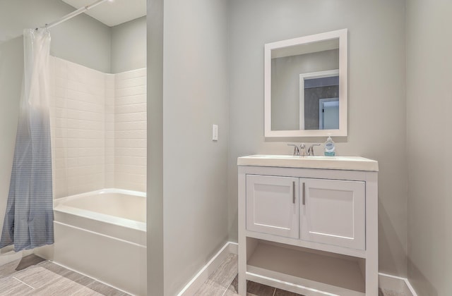 bathroom featuring vanity, shower / bath combo with shower curtain, baseboards, and wood finished floors