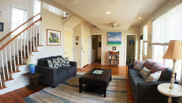 living room with dark wood-type flooring, ceiling fan, and a healthy amount of sunlight