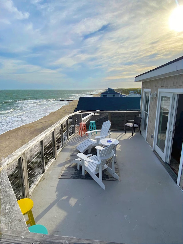 view of patio featuring a beach view and a water view