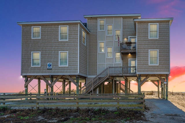 back house at dusk featuring a balcony