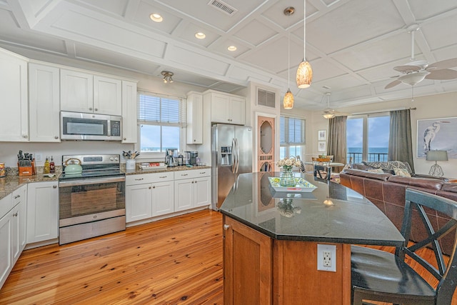 kitchen with stainless steel appliances, white cabinetry, and coffered ceiling