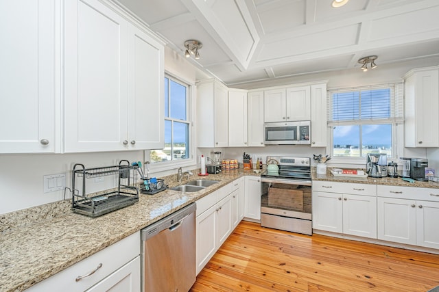 kitchen featuring appliances with stainless steel finishes, white cabinetry, and sink