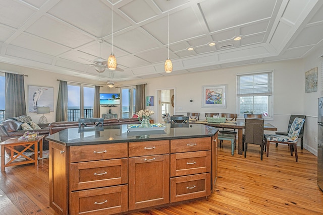 kitchen with coffered ceiling, a center island, pendant lighting, and light hardwood / wood-style flooring