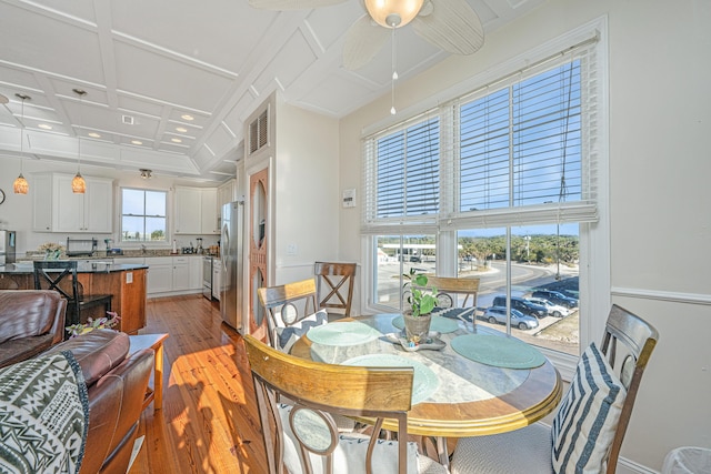 dining space with beamed ceiling, ceiling fan, light hardwood / wood-style floors, and coffered ceiling