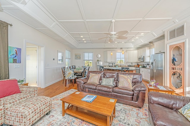 living room with coffered ceiling, ceiling fan, and light hardwood / wood-style flooring