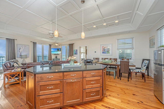 kitchen with plenty of natural light, light hardwood / wood-style floors, and coffered ceiling