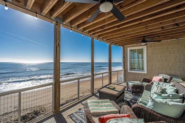 exterior space with outdoor lounge area, a water view, and a beach view