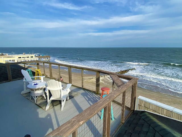 balcony featuring a view of the beach and a water view