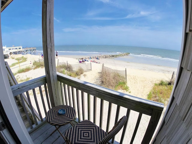 balcony featuring a beach view and a water view