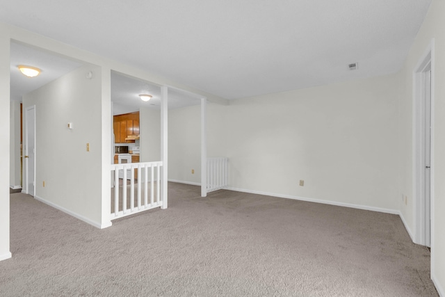 spare room with baseboards, carpet flooring, and radiator heating unit