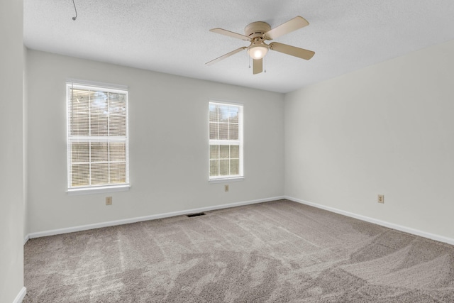 spare room with visible vents, carpet flooring, ceiling fan, a textured ceiling, and baseboards